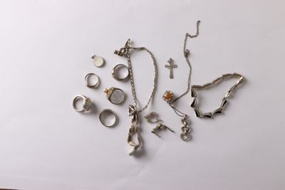 a lot of silver jewelry on a white surface