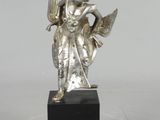 statue en argent représentant une femme tenant un oiseau, posée sur un socle noir