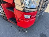 a close up of a red truck ' s headlight and front bumper