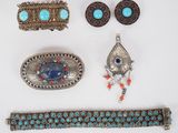 an assortment of silver and turquoise jewelry including a belt, bracelet, and broochet