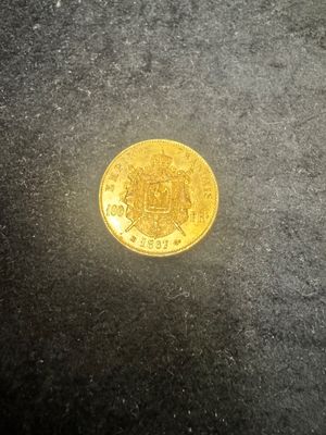 gros plan d'une pièce d'or sur une surface noire