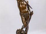 statue en bronze représentant un homme tenant une épée, debout sur un rocher