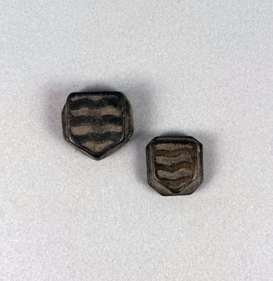 two pieces of metal that are sitting on top of a white surface