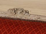 a close up of a red and white chair with a wood frame
