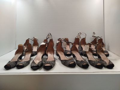 Neuf paires de chaussures sont alignées sur une étagère dans une vitrine.