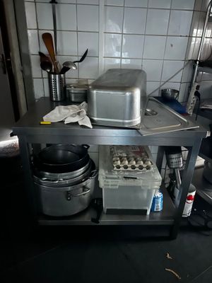 a small kitchen with a stove, oven, and pans on the counter
