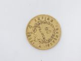 a gold coin with a wreath on the front of it
