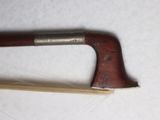 a small wooden stick with a handle on a white surface
