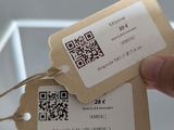 a person holding a tag with a qr code on it