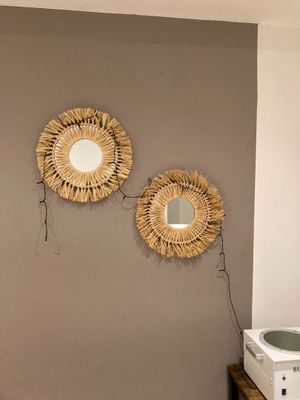 deux miroirs accrochés au mur au-dessus d'un micro-ondes et d'un four à micro-ondes