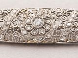 a close up of a silver broochle on a white surface
