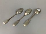 three silver spoons sitting on top of a table next to each other
