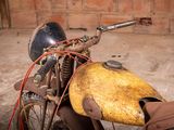 an old motorcycle with a yellow helmet on the back of it