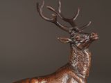 bronze sculpture of a stag with antlers on a black background