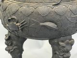 a large metal pot that has a dragon on it