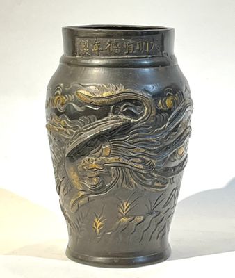 un vase orné d'un dragon posé sur une table