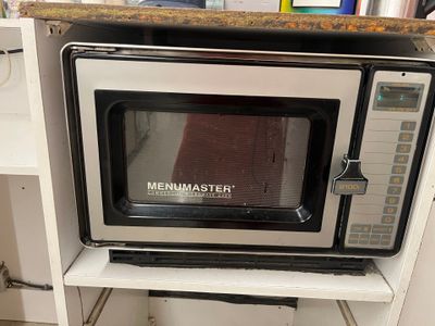 a microwave sitting on top of a shelf in a kitchen