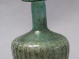 un vase vert posé sur une table
