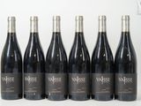six bouteilles de vin sont alignées sur une table