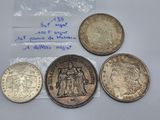 four different types of coins are on a table with a price tag