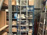 une échelle au milieu d'une pièce, sur laquelle sont posées de nombreuses boîtes
