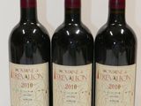 trois bouteilles de vin rouge sont alignées sur une table
