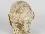 a close up of a clay head on a white surface