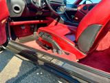 une voiture de sport rouge avec des sièges rouges et un volant
