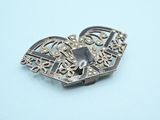 a close up of a silver brooch with a heart on it