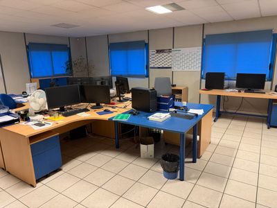 une image représentant un bureau avec de nombreux bureaux et ordinateurs