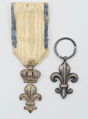 une image représentant une médaille et un porte-clés posés sur une surface blanche