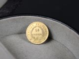 une pièce d'or posée dans une boîte sur une surface noire