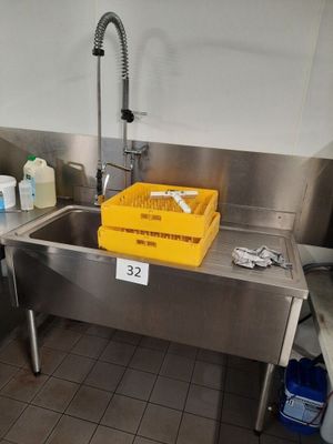 a sink with a yellow basket in it in a kitchen