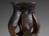 a close up of a brown vase with holes in it
