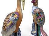two figurines of birds that are standing next to each other