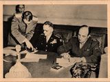 une photo en noir et blanc d'un groupe d'hommes assis à une table
