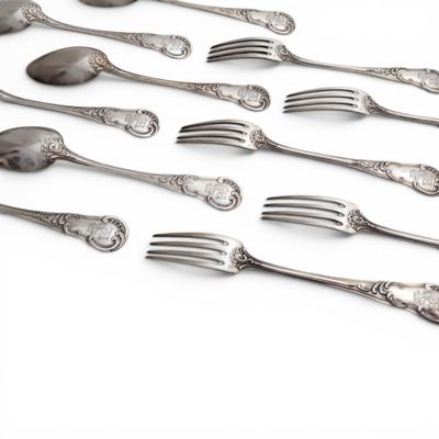a lot of forks and spoons on a white surface