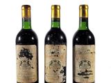 trois bouteilles de vin sont alignées sur une surface blanche