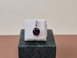 a close up of a ring with a red stone on a marble block