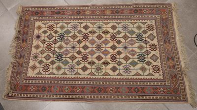 un vieux tapis posé à même le sol dans une pièce carrelée