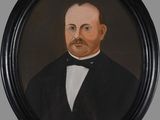 portrait of a man in a tuxedo in a black frame