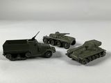 three toy army vehicles sitting on top of a white surface