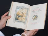 une personne tenant un livre ouvert sur lequel figure l'image d'un ours polaire