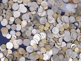 a pile of silver and gold coins on a blue table