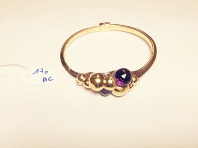 a close up of a gold ring with a purple stone on it