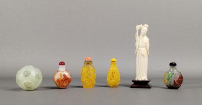 Plusieurs bouteilles en verre et figurines sont alignées sur une surface grise