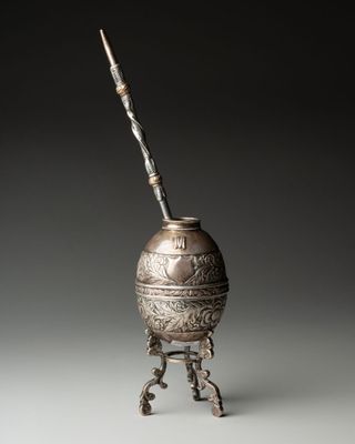 un vieux vase en argent d'où sort un bâton