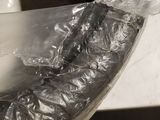 a plastic bag wrapped around a metal bowl on a counter