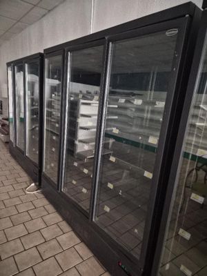 a long line of refrigerators that are lined up in a store