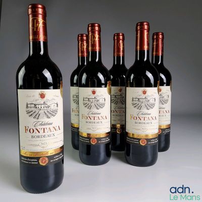 quatre bouteilles de vin rouge sont alignées sur une table